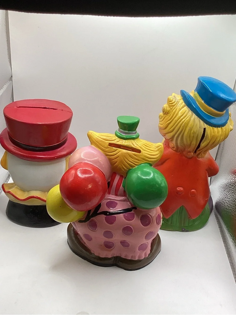 Three vintage 1980s hard plastic circus clown coin banks